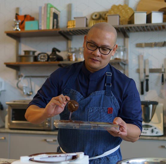 Chef Nouel pouring melted chocolate into molds.